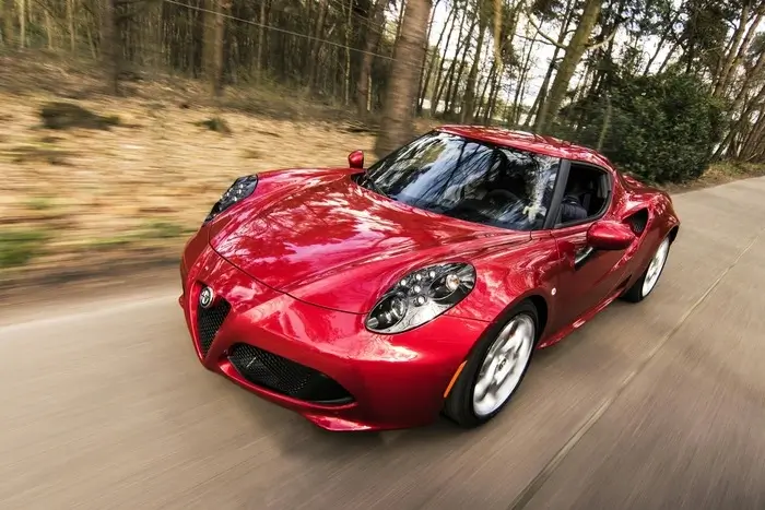 A red sports car speeding down a road, showcasing its high horsepower