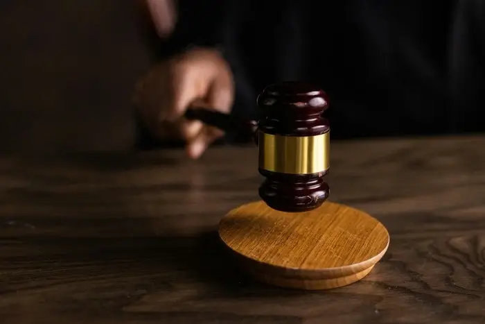 A close-up of a judge's gavel being struck on a wooden block.