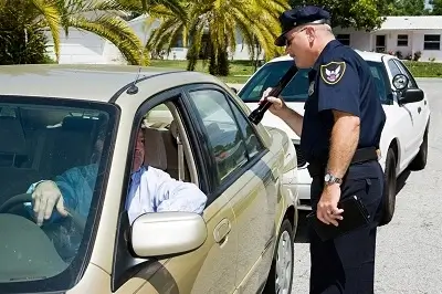 A police officer conducting a DUI checkpoint stops and questions a driver