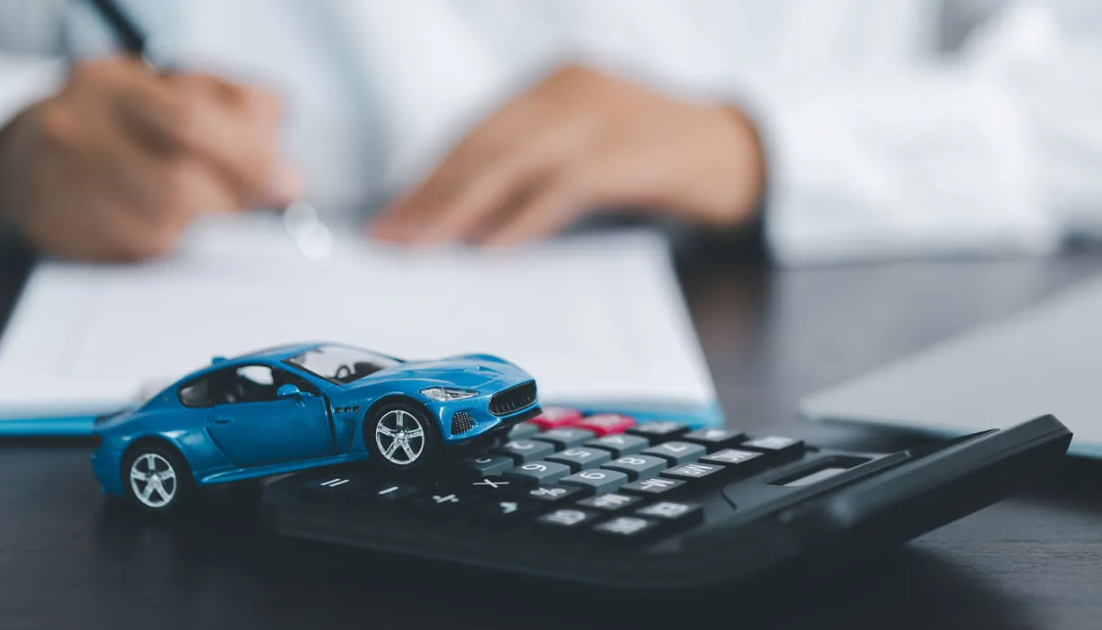 Blue Toy Car In Front Of Insurance Agent Calculating Auto Insurance Costs