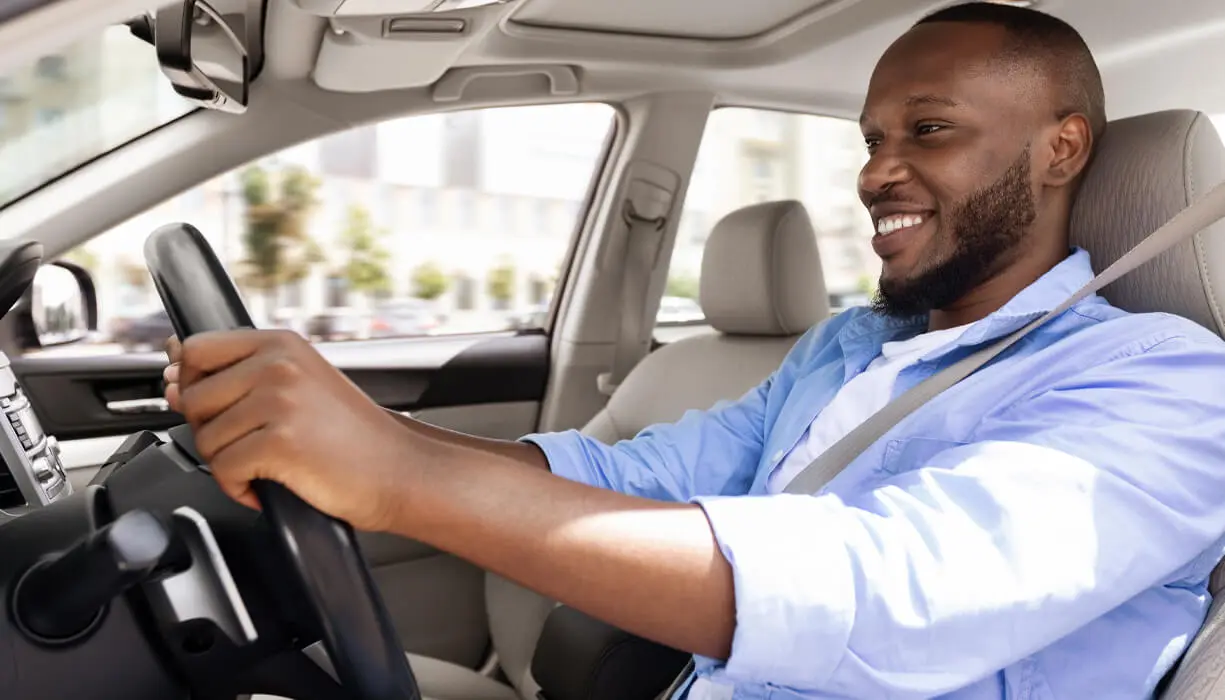 A man confidently drives his car after regaining his driving privileges after a DUI violation